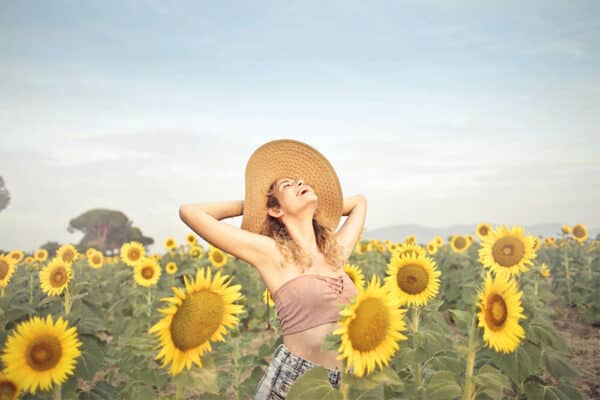 Happy woman standing in a field of sunflowers